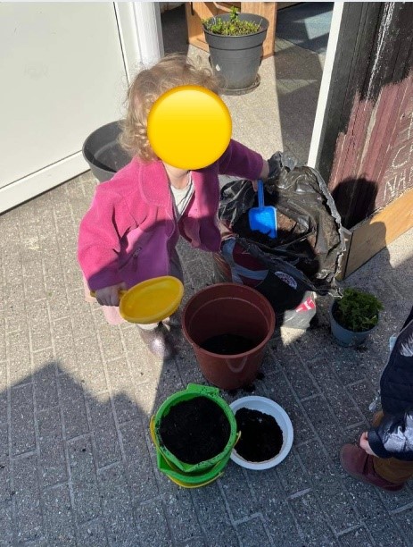 Barn der står klar til at hjælpe med at plante potteplanter